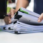 ddvvvv Paperwork files searching information business concept, Businessman hands typing keyboard computer, working in stacks of report papers and piles of unfinished documents achieves on office desk